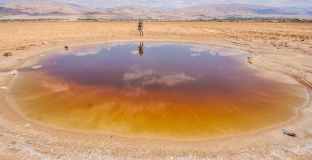Dead Sea, Jordan - the Jordan side of the Dead Sea offers a much wilder and colorful view of the lake. Here in particular a waterpool with a golden toneの写真素材