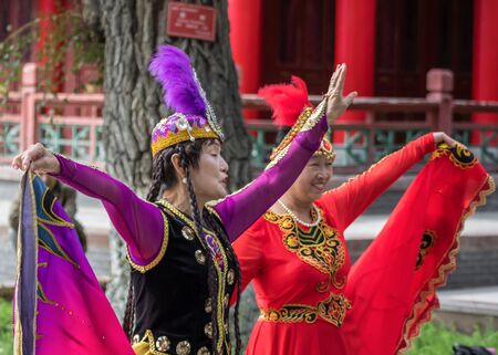 Urumqi, China - capital of the Xinjiang Uygur Autonomous Region, Urumqi is home of the colorful and welcoming Uyghur ethnic group. Here in particular two women dancing in People's Parkのeditorial素材
