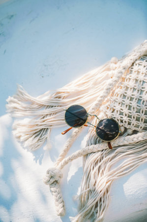 round sunglasses on knit bag on white background