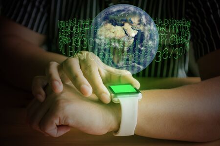 Hand of Woman use Wireless Digital Touchscreen Smart Watch Wearable Gadget Device with Hologram of Text Remind on wood Table as Business Modern Technology Lifestyle Conceptの写真素材