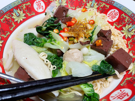 Chinese noodle soup with pork and vegetables, closeup of photo