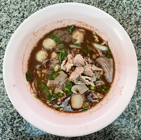 Thai noodle soup with pork and fish ball in pink bowl