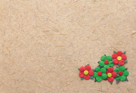 Brown natural handmade paper with red and green flowersの写真素材