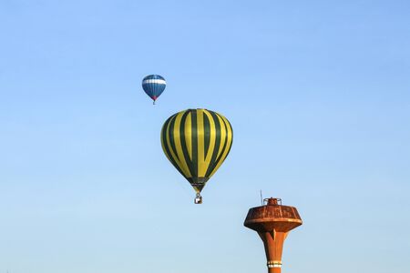 Flying colourful balloon on the blue sky in the morningの写真素材