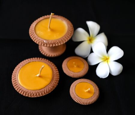 Natural product the clay candle with the plumeria flower at the backgroundの写真素材