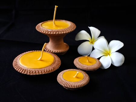 Natural product the clay candle with the plumeria flower at the backgroundの写真素材