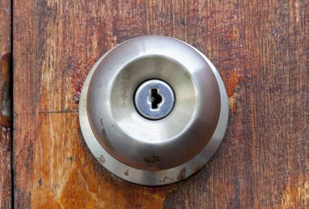 Dirty doorknob with the wooden doorの写真素材