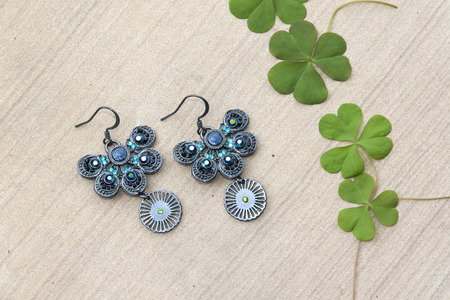 Beautiful butterfly shape earring and green leavesの写真素材