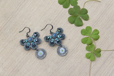 Beautiful butterfly shape earring and green leavesの写真素材