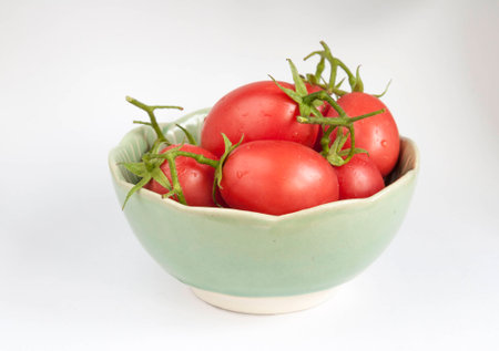 Close-up fresh tomatoes in green bowlの写真素材
