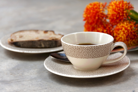 coffee cup and bread with orange flower backgroundの写真素材