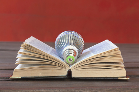 Light bulb on the book with space on red cement wall backgroundの写真素材