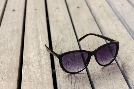 Women sunglasses on wooden floor vintage tone styleの写真素材