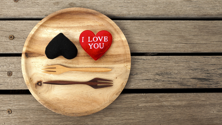 Black and red heart with space on wood floorの写真素材