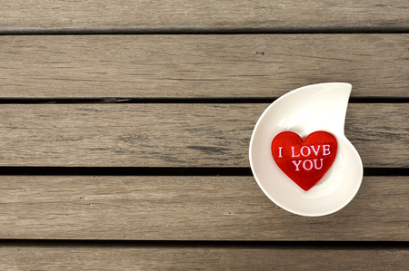 Red heart with space on wood floorの写真素材