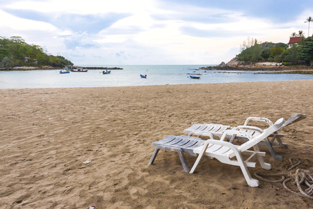 White chair on the beach in early morning lightの写真素材