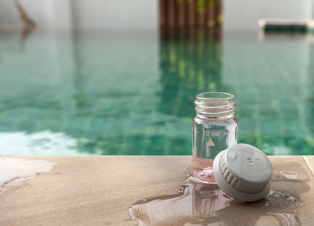 Water testing glass bottle with space on swimming poolの写真素材