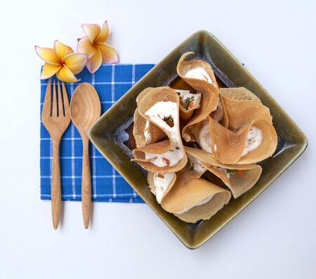 Thai crispy pancake on blue napkin with space on white backgroundの写真素材