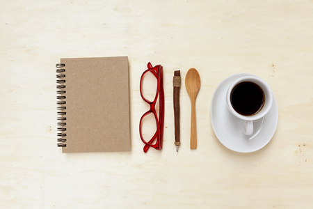 Blank brown notebook and coffee cup with space on wood backgroundの写真素材