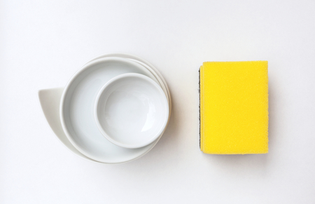 Cleaning sponge and ceramic dish with space on white backgroundの写真素材