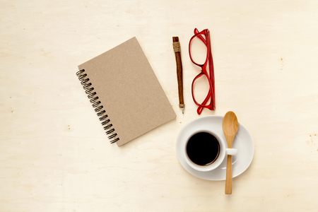 Brown notebook on working table with coffee and eyeglassesの写真素材