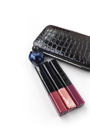 Lips gloss with leather clutches bag and a blue perfume bottle with space on white background vertical styleの写真素材