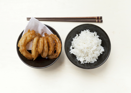Golden onion ring and rice on wood tableの写真素材