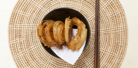 Golden onion ring on rattan placemat food banner styleの写真素材