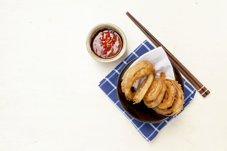 Golden onion ring with chili sauce on wood tableの写真素材
