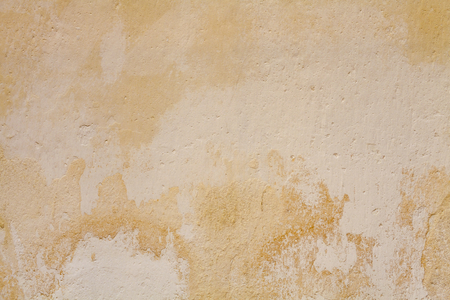 Old yellow paint cement wallの写真素材