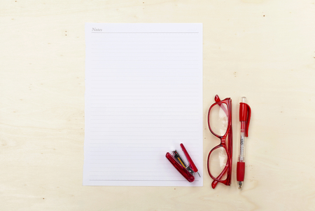 White note on wood background with eyeglasses and penの写真素材