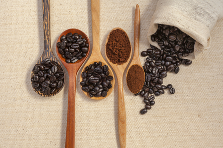Closeup coffee beans in wooden spoon background selective focusの写真素材