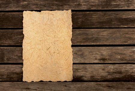 Burnt edges natural texture paper with space on dark wood floorの写真素材