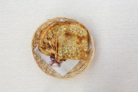 Garlic bread in rattan basket on canvas texture backgroundの写真素材