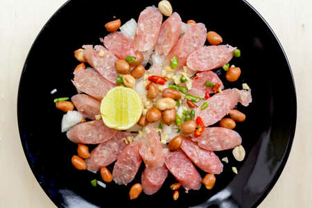 Closeup Thai sour pork sausage salad in black plateの写真素材