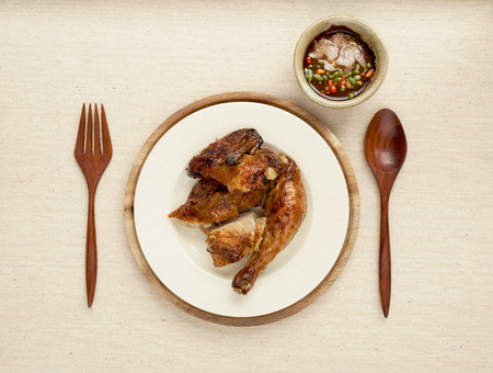Grilled chicken with spicy chili sauce on canvas backgroundの写真素材