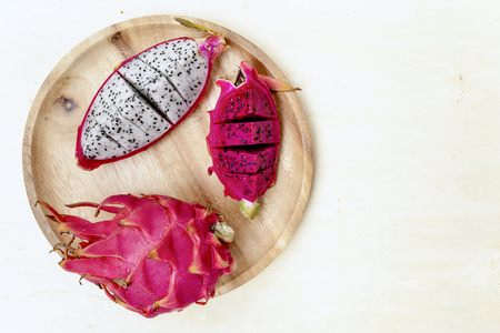 Dragon fruit on wooden plate with space on backgroundの写真素材