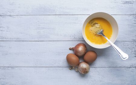 Eggs and red onion with space on backgroundの写真素材