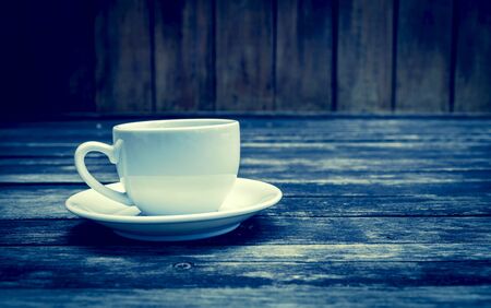 Vintage cool tone coffee cup on wood floorの写真素材
