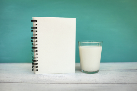 Blank notebook and a glass of fresh milkの写真素材