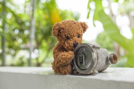 Wet Teddy bear and old water meterの写真素材