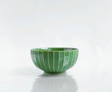 Green ceramic cup on white backgroundの写真素材