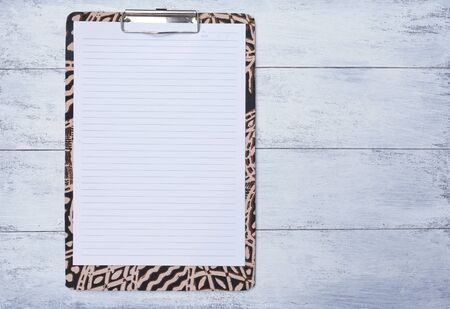 Blank note pad on colorful paper clipboard with space on wood floorの写真素材