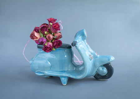 Red roses bouquet on blue scooterの写真素材