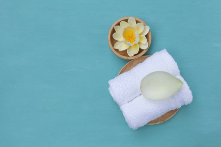 White towel with lotus leaf and flower on blue backgroundの写真素材