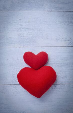 Two red hearts with space on white wood backgroundの写真素材