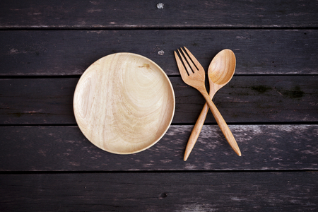Wooden plate set on dark wooden floorの写真素材