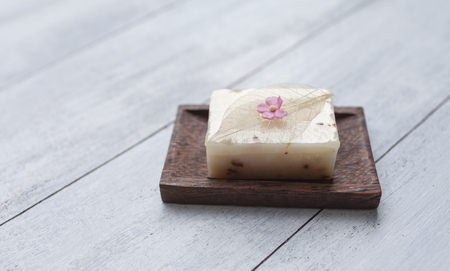 Close up natural soap bar on wooden soap dish with space on wood tableの写真素材