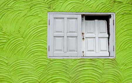 The green wall design with broken white wooden windowの写真素材