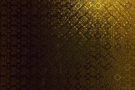 Dark gold light glass wall thai pattern backgroundの写真素材